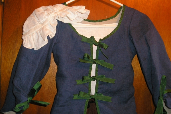 detail of frilled cap or bonnet and ribbon  binding and ties on jacket